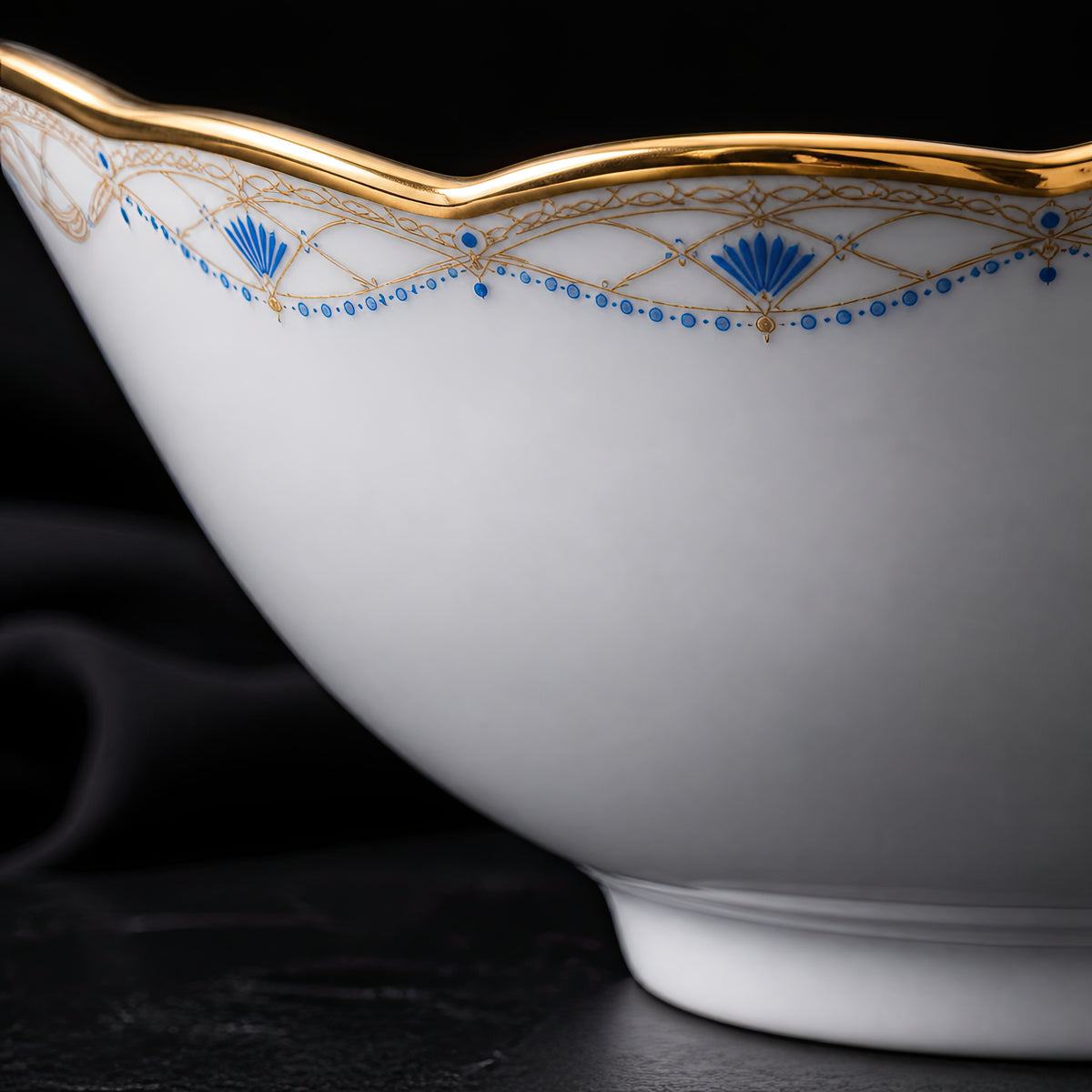 Low side close-up of the Valesse Azure 14.9 cm fruit bowl highlighting its footed base and blue-and-gold rim decoration.