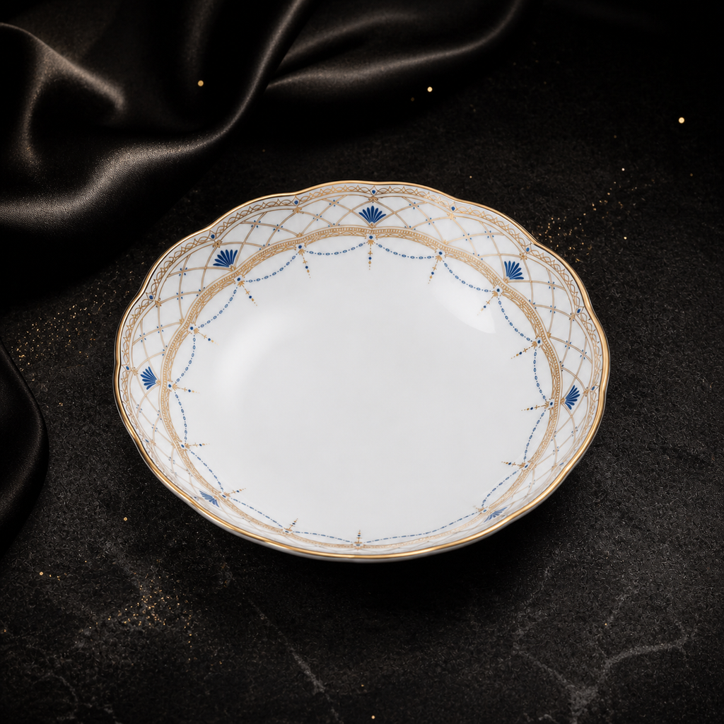 High-angle view of the empty Valesse Azure 14.9 cm fruit bowl with its luminous white interior and ornate blue-and-gold border.