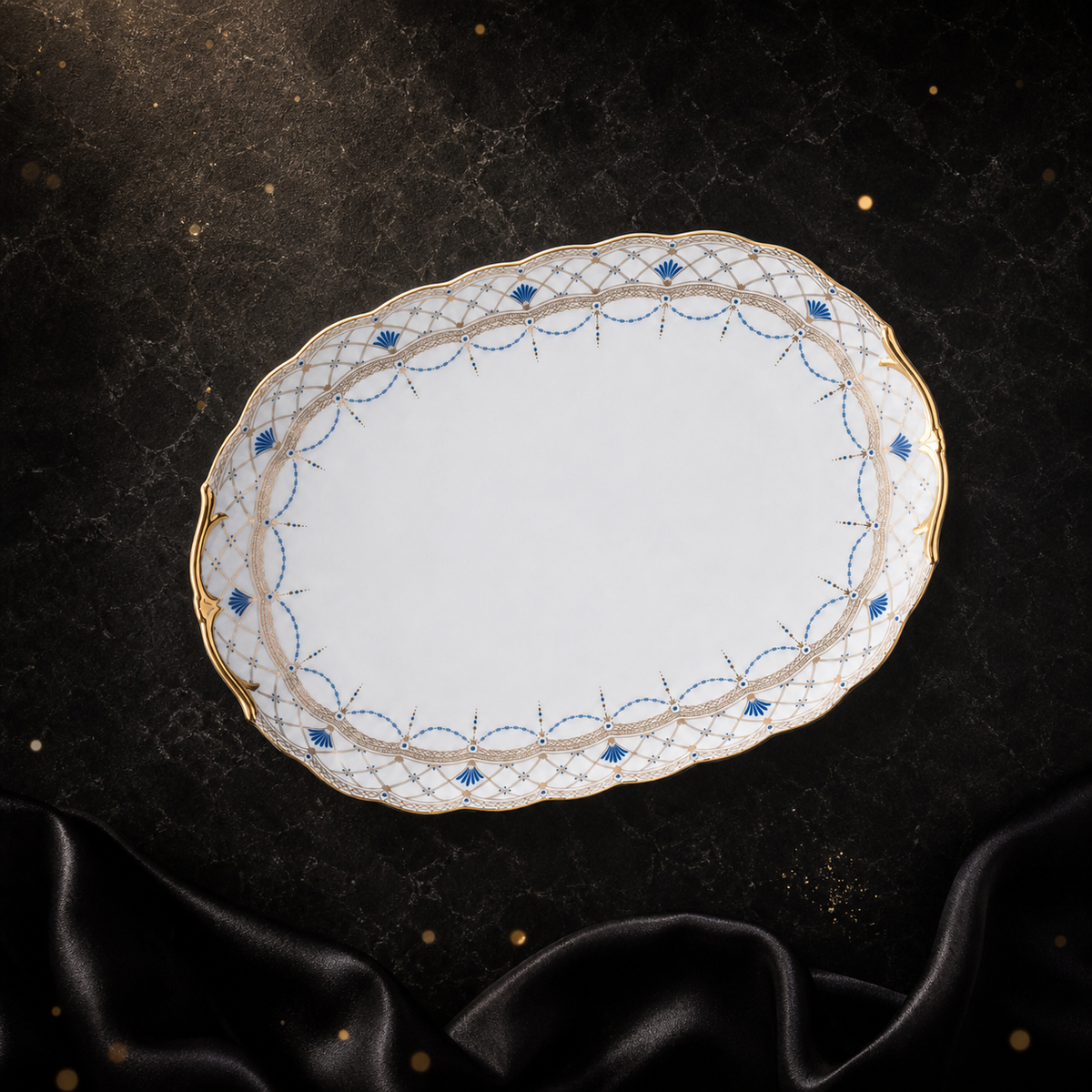 High-angle view of the empty Valesse Azure 33 cm oval platter, showing its broad serving area and ornate scalloped border.