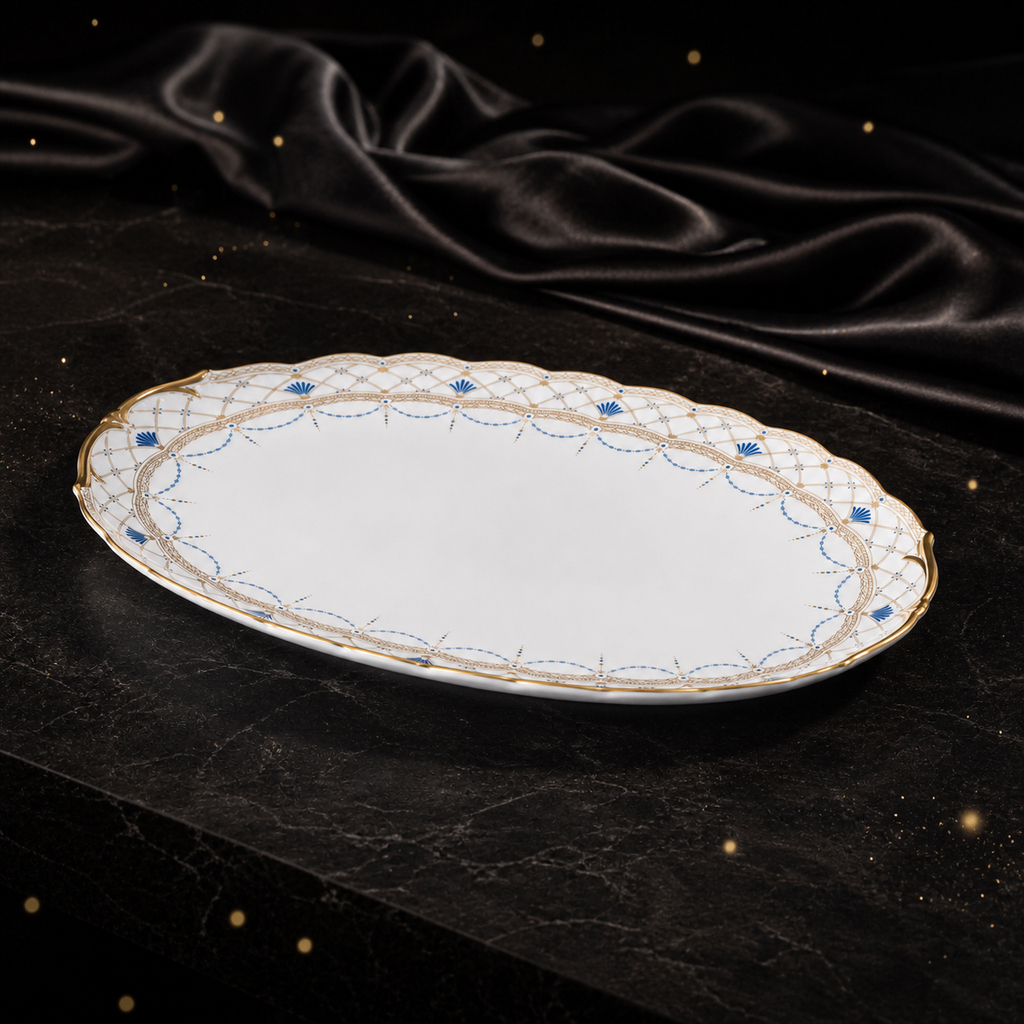 Low-angle view of the Valesse Azure oval platter showing its shallow bone-china profile and gold-edged sculpted rim.