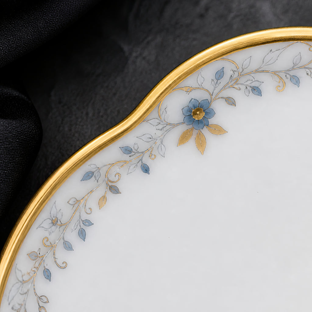 Close-up of the Valesse Azure petit dish showing its scalloped rim, fine gold latticework and small blue accents.