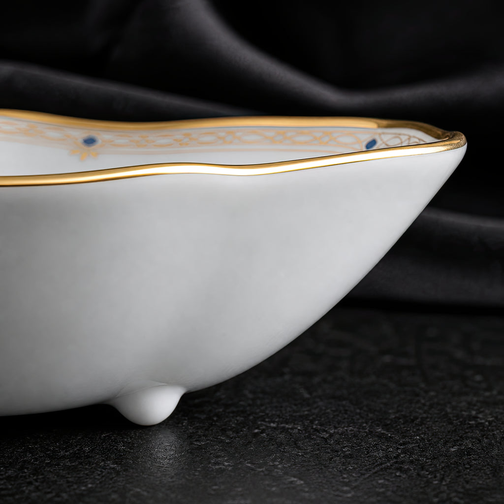 Low side close-up of the Valesse Azure 9.1 cm petit dish highlighting its shallow bone-china profile, gold rim and raised foot.