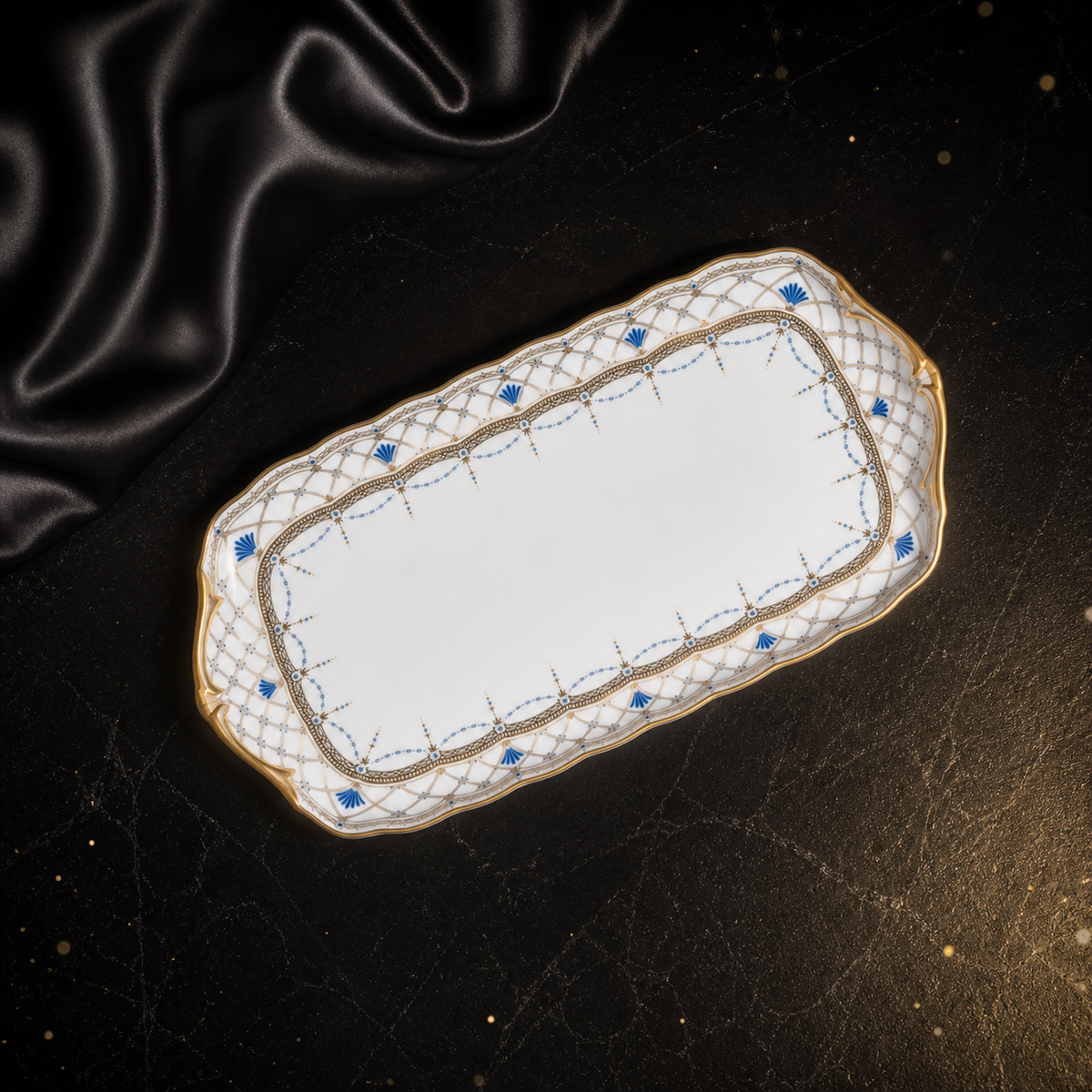 Angled overhead view of the Valesse Azure small tray with its white center, blue accents and ornate gold lattice border.