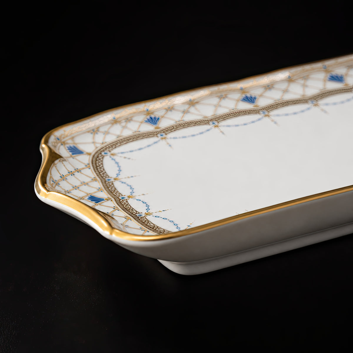 Low side close-up of the Valesse Azure 23 cm small tray highlighting its shallow profile, curved corner and gold rim.
